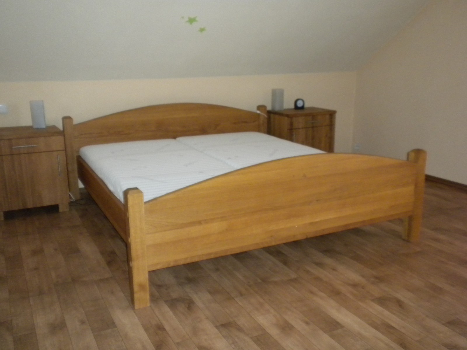 Dřevěná postel s nočními stolky v ložnici